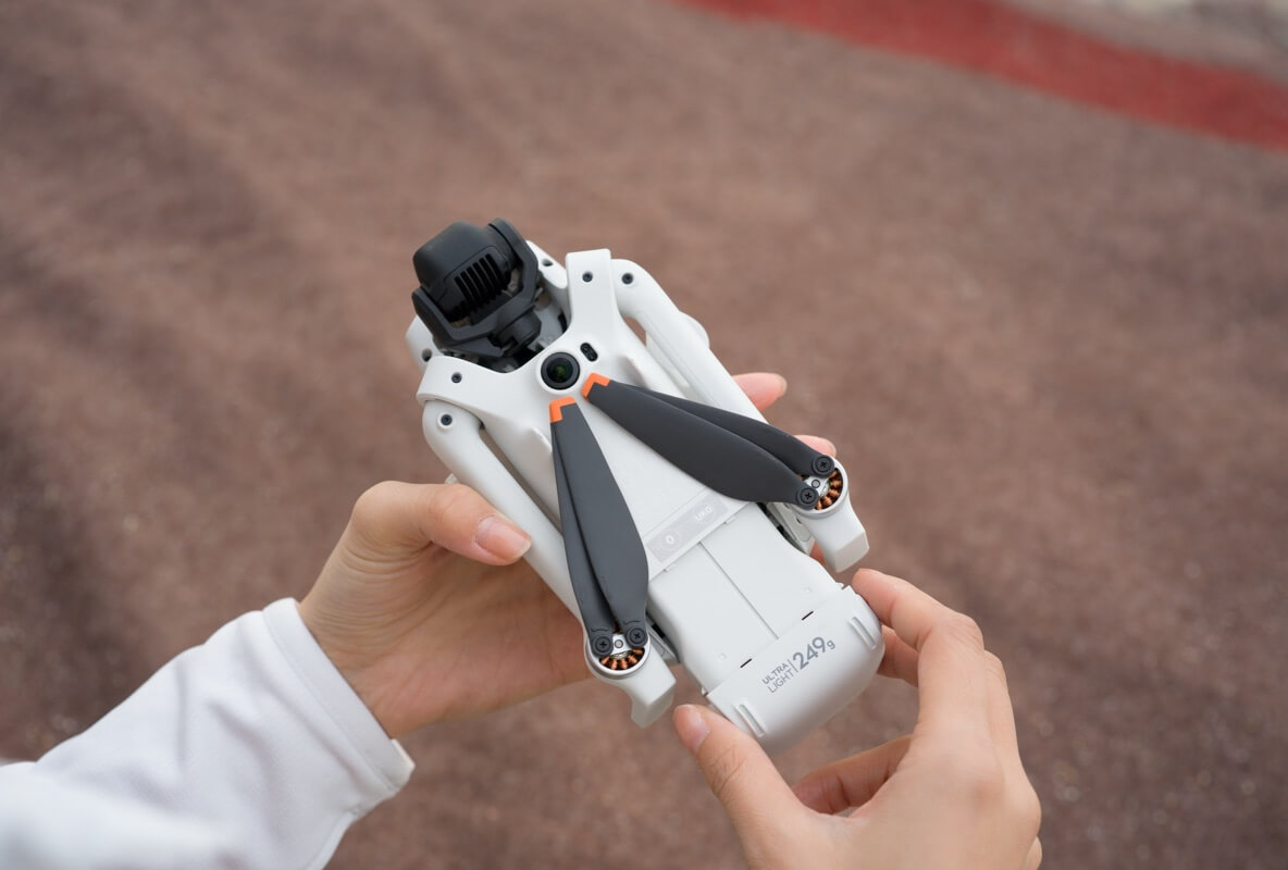 DJI Lito 1 folded in two hands, showing the ‘Ultra Light · 249g’ marking
