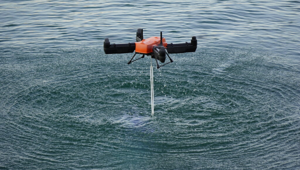 Hovering just above the water surface with a bait line dripping from its release mechanism